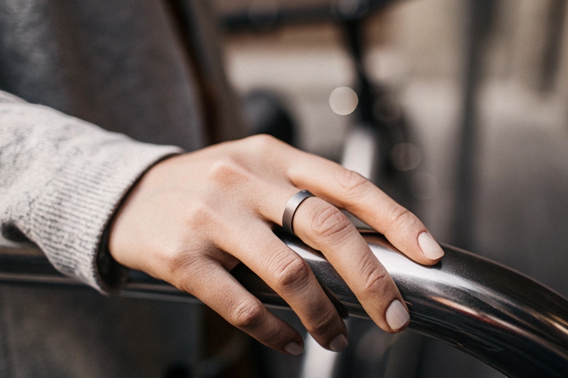 A hand wearing a brushed titanium ring