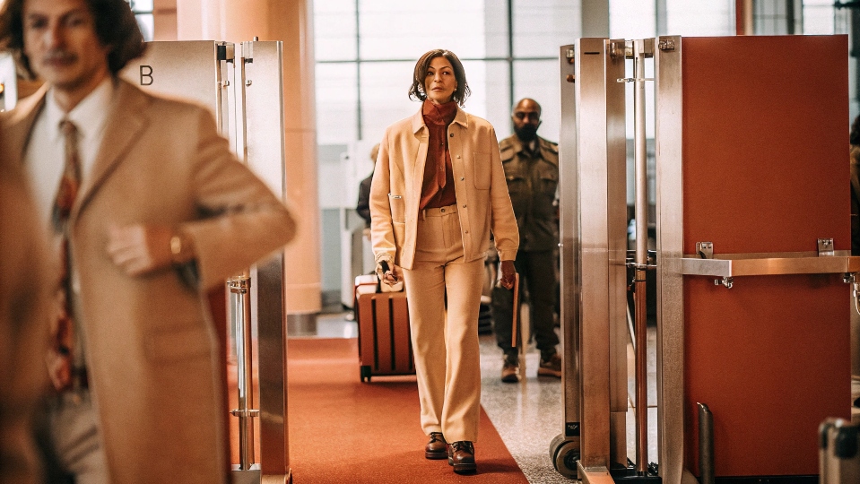 A person confidently walking through an airport security scanner without setting off any alarms.