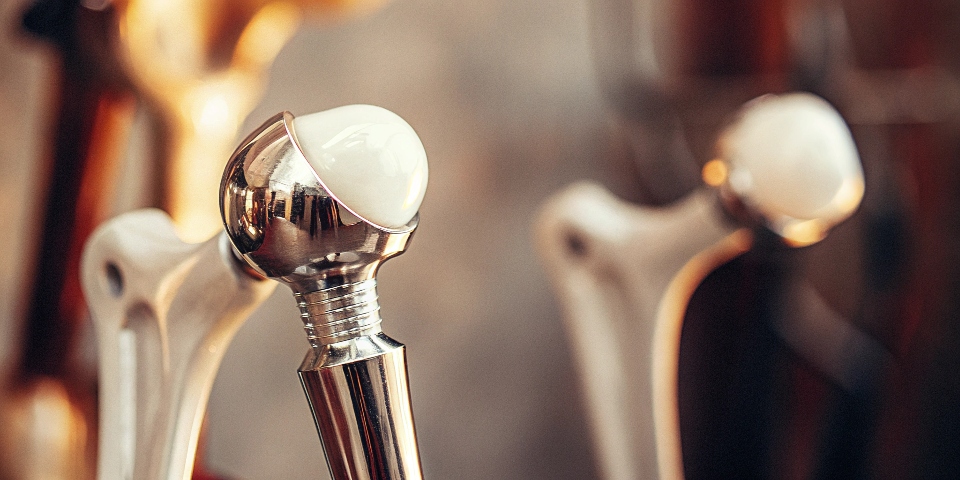 A photo of a medical-grade titanium hip implant, clean and polished.