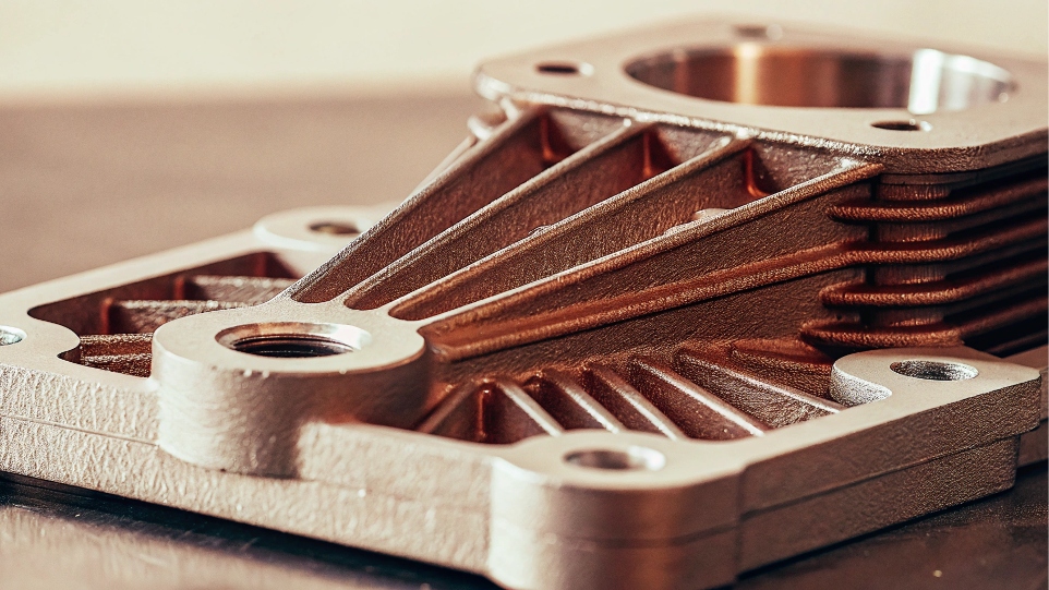 An intricate 3D-printed aerospace bracket made from titanium powder.