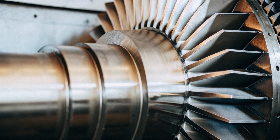 A close-up of a commercial jet engine turbine blades made of titanium alloy.