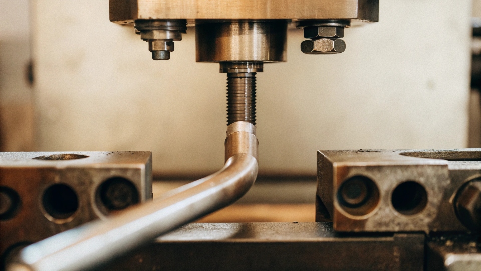 A CNC mandrel bending machine precisely forming a titanium U-bent tube