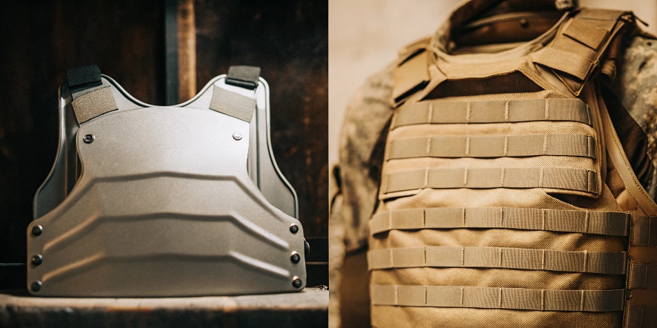 A titanium body armor plate next to a bulletproof vest.