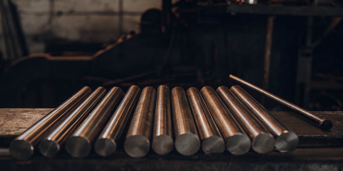 A display of raw beta titanium rods and bars in a factory setting.