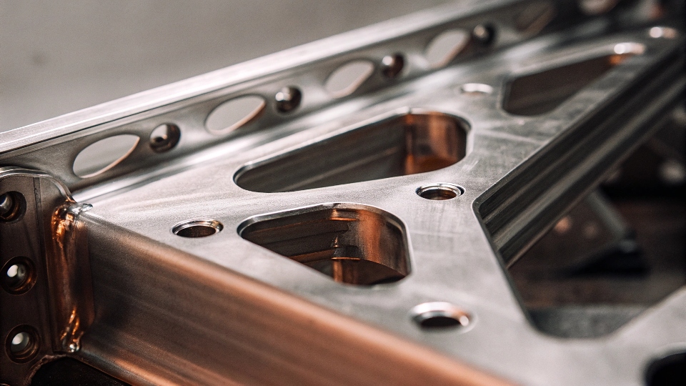 A close-up shot of a titanium heat exchanger or complex titanium bracket used in an aircraft