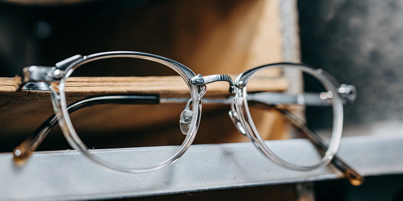 A pair of flexible titanium eyeglass frames being twisted
