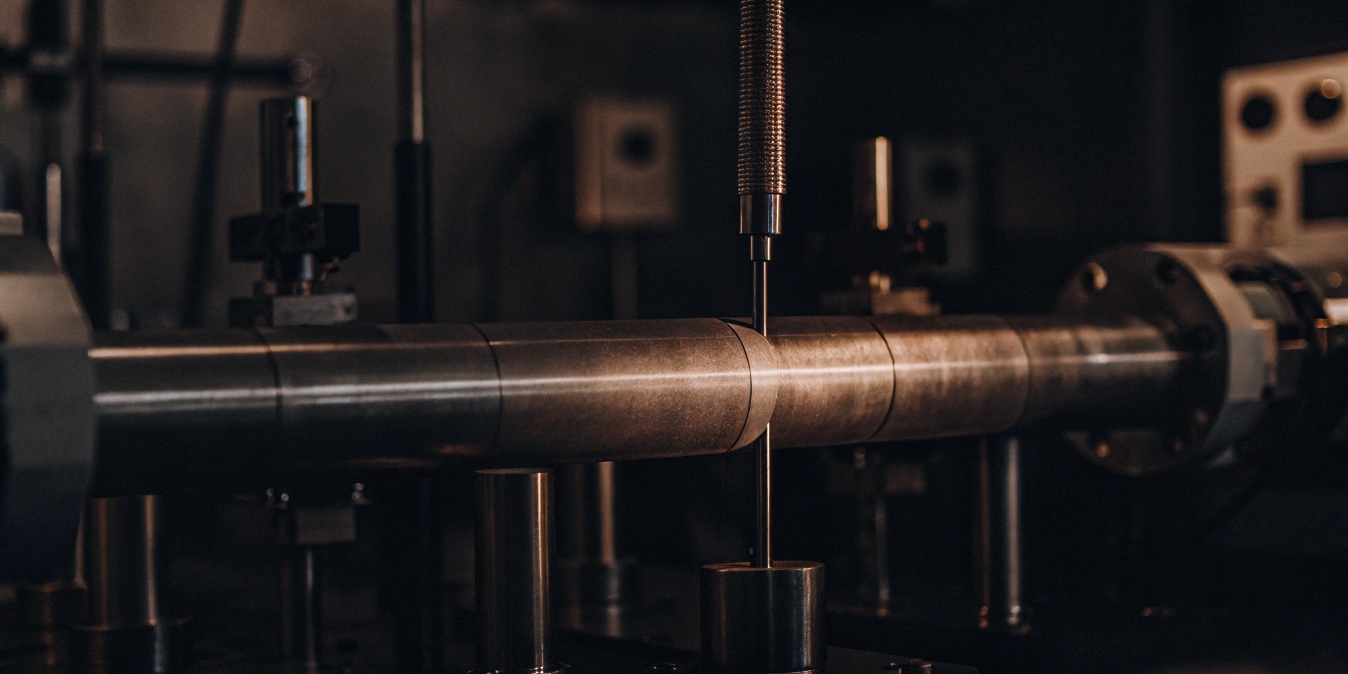 A titanium tube undergoing a tensile strength test in a lab